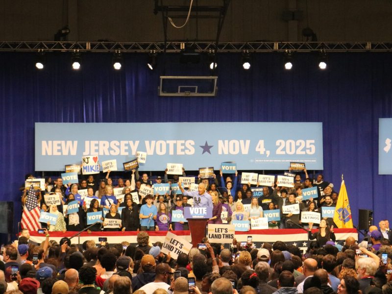 Obama speaks in a crowded room with people holding signs