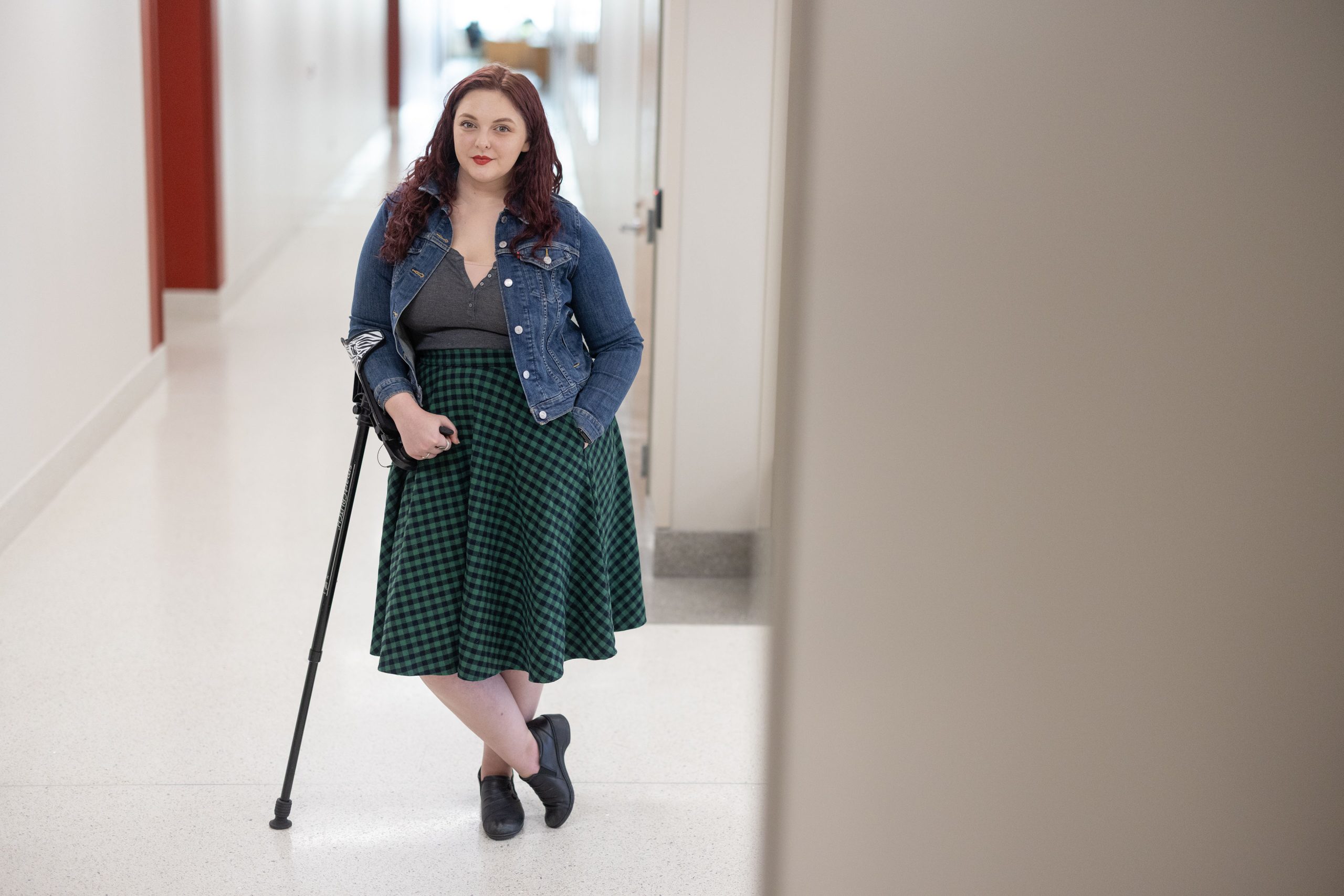 A portrait of a young woman leaning on a cane.