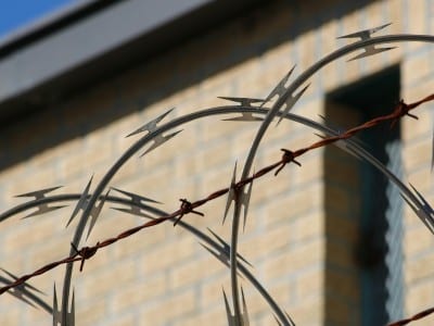 Close-up shot of barbed wire in front of brick building