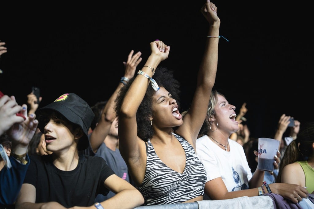 Diverse group of young people enjoying a live concert, expressing excitement and enthusiasm.